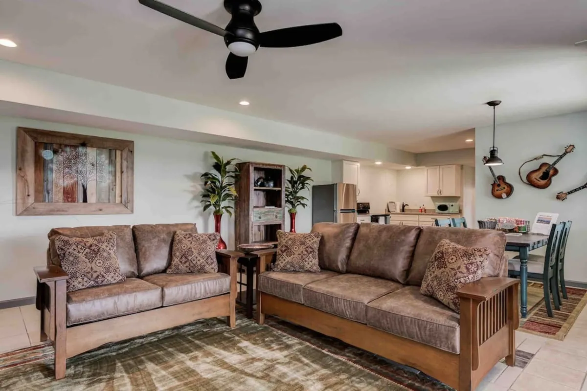 A cozy lounge area outfitted with comfortable sofas, wooden furniture, musical instruments, and decorative wall art, perfect for relaxing, socializing, and enjoying group activities after the excitement of game night.